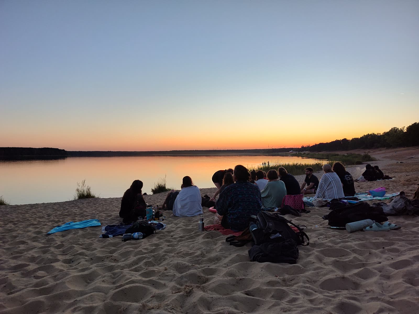 Abends am See, die Crew sitzt im Sand